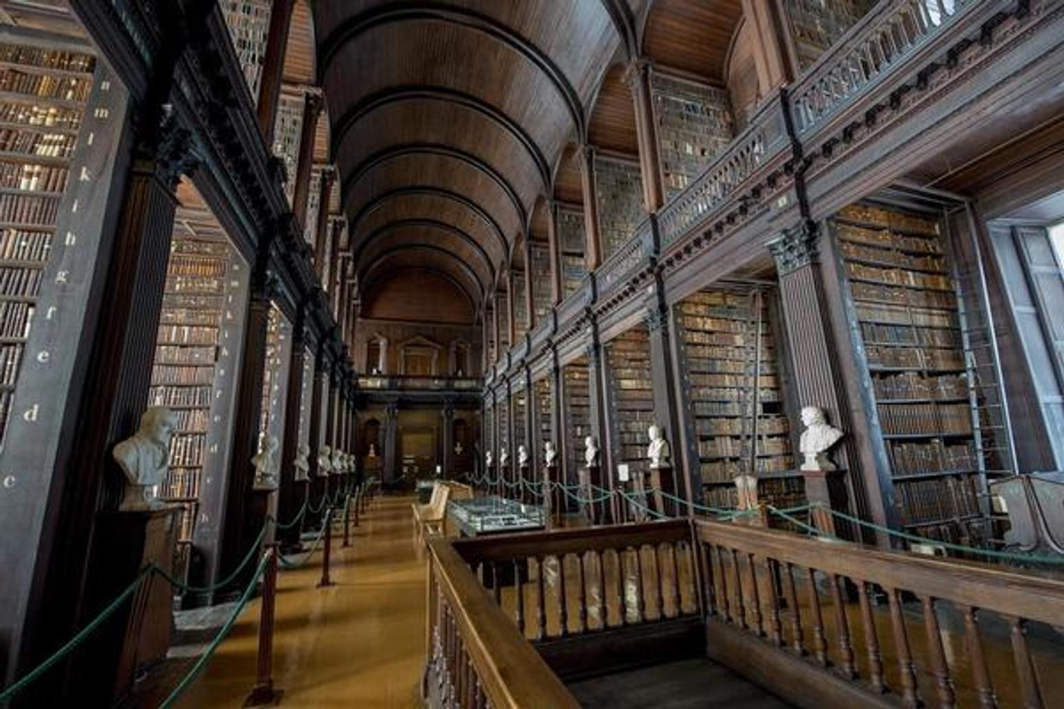 Die beeindruckende Long Room Bibliothek des Trinity College in Dublin mit hohen Bücherregalen und historischem Charme.