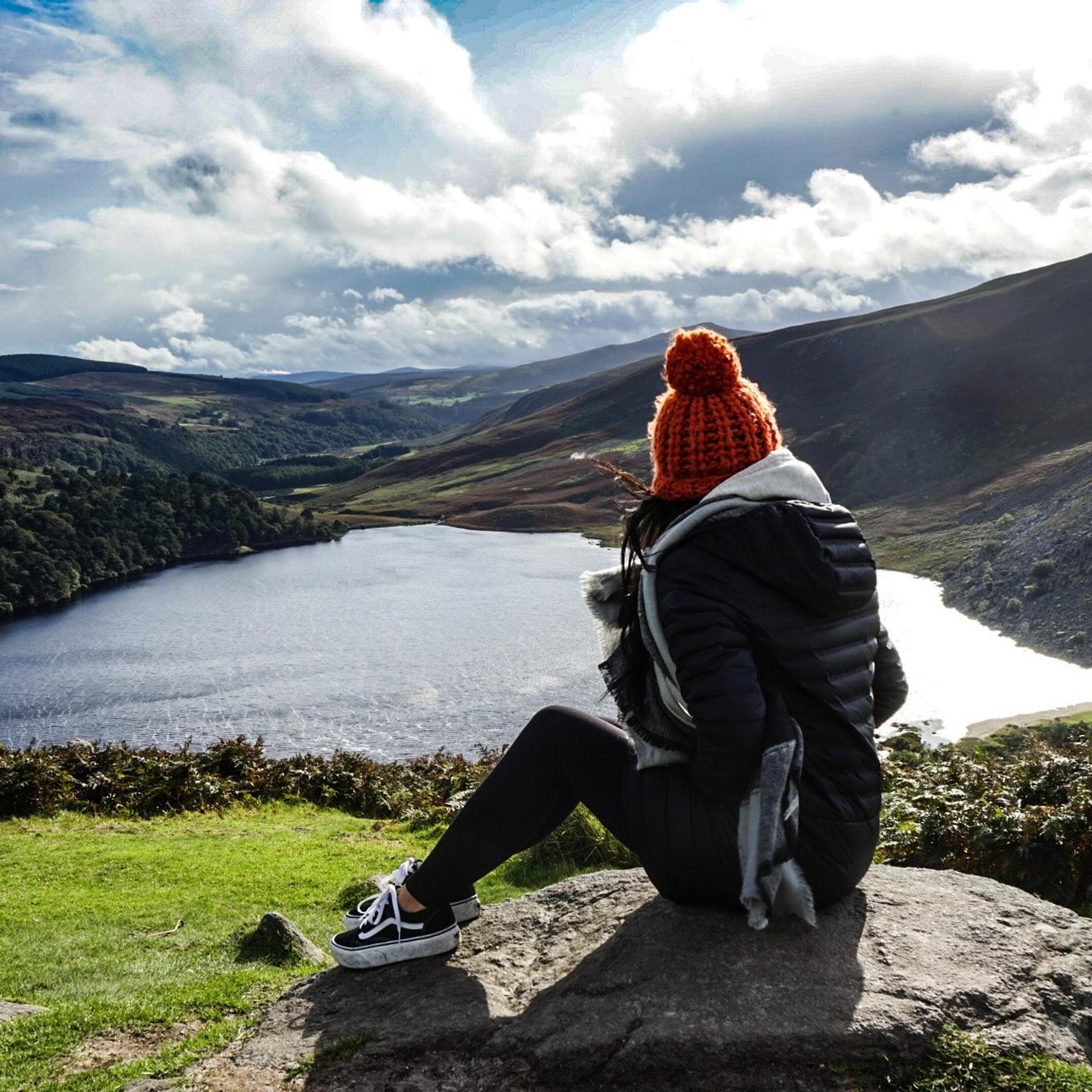 Ein Mädchen überblickt einen See in Irland