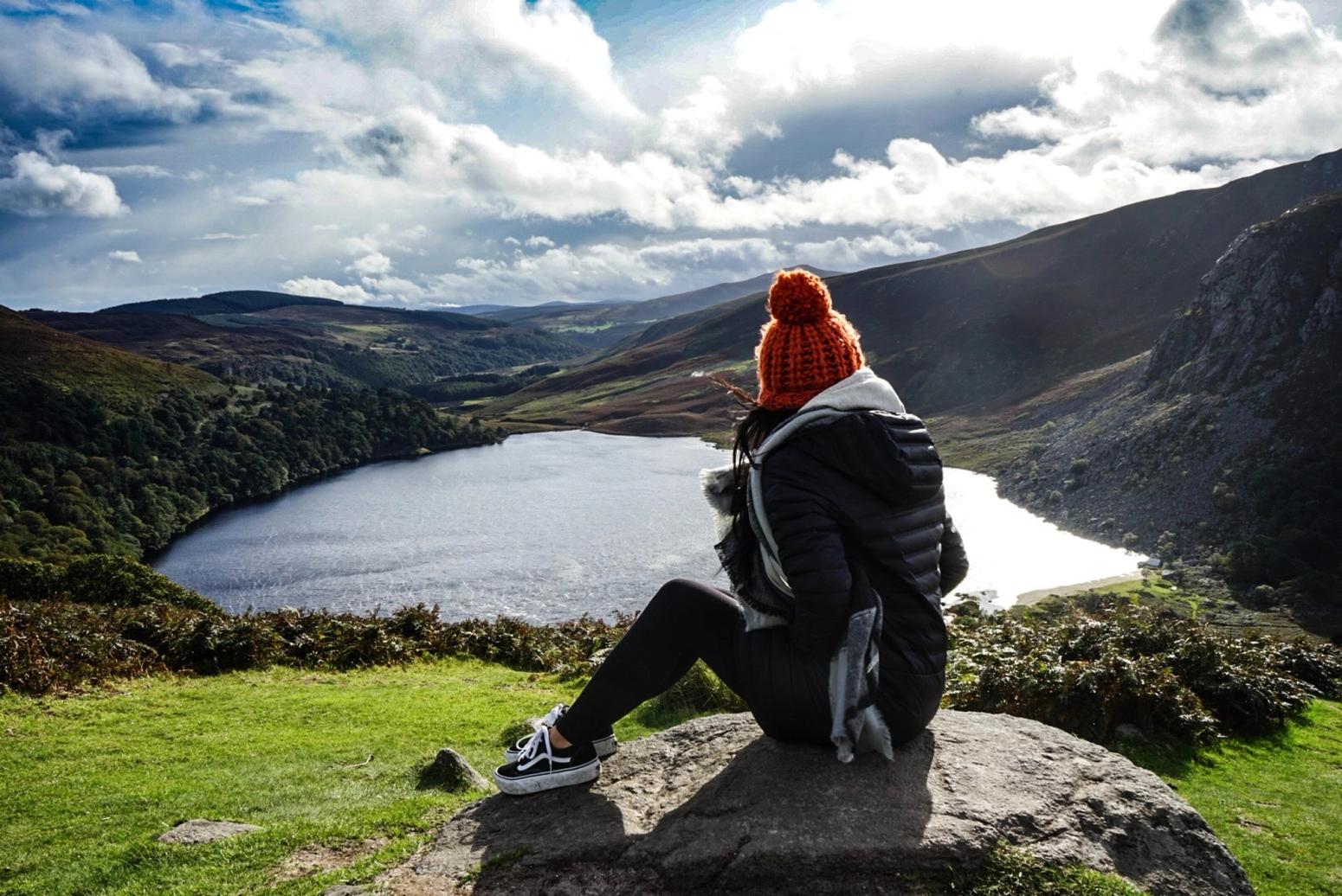 Ein Mädchen überblickt einen See in Irland