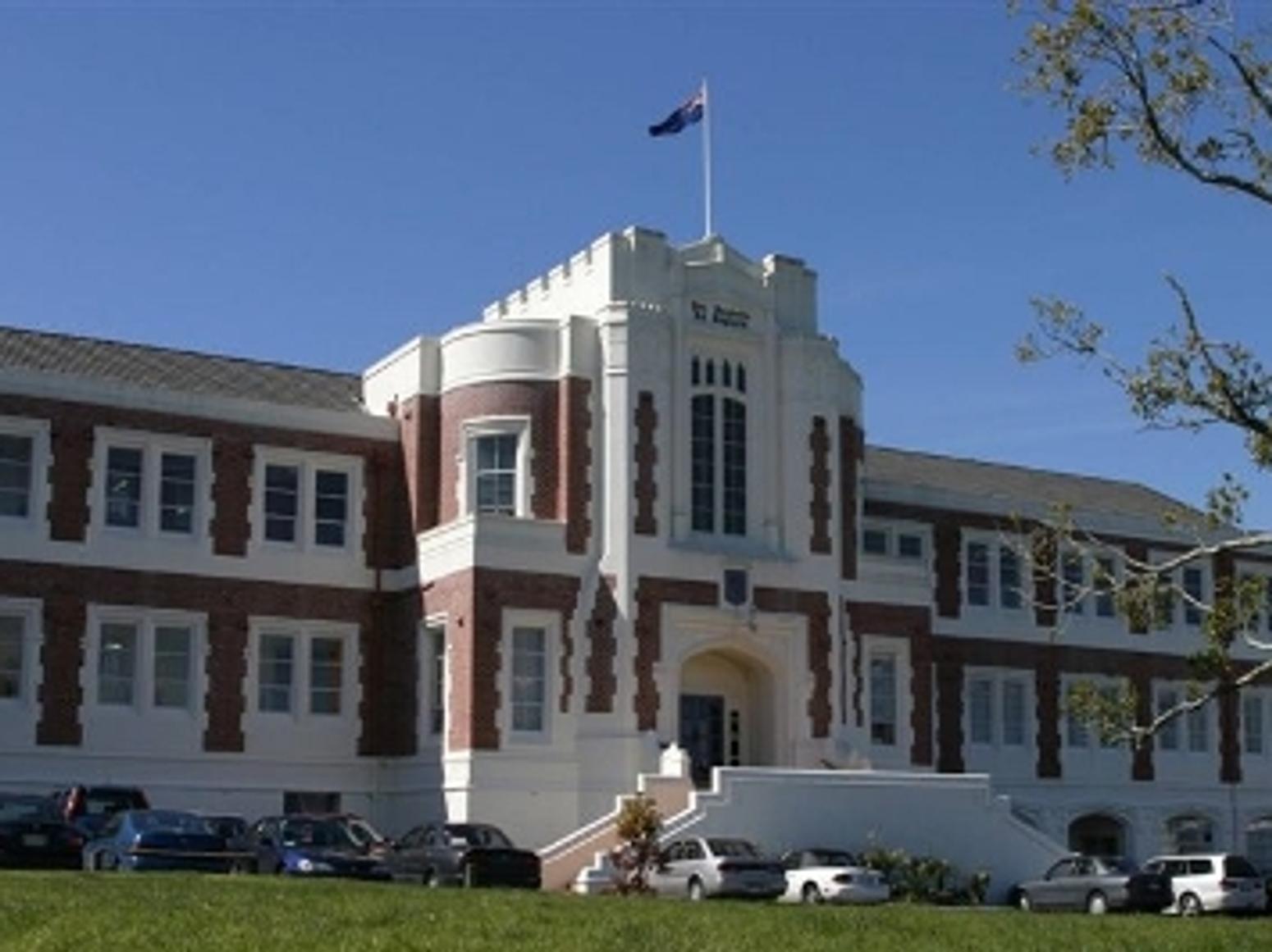 Schulgebäude von vorne mit Fahne