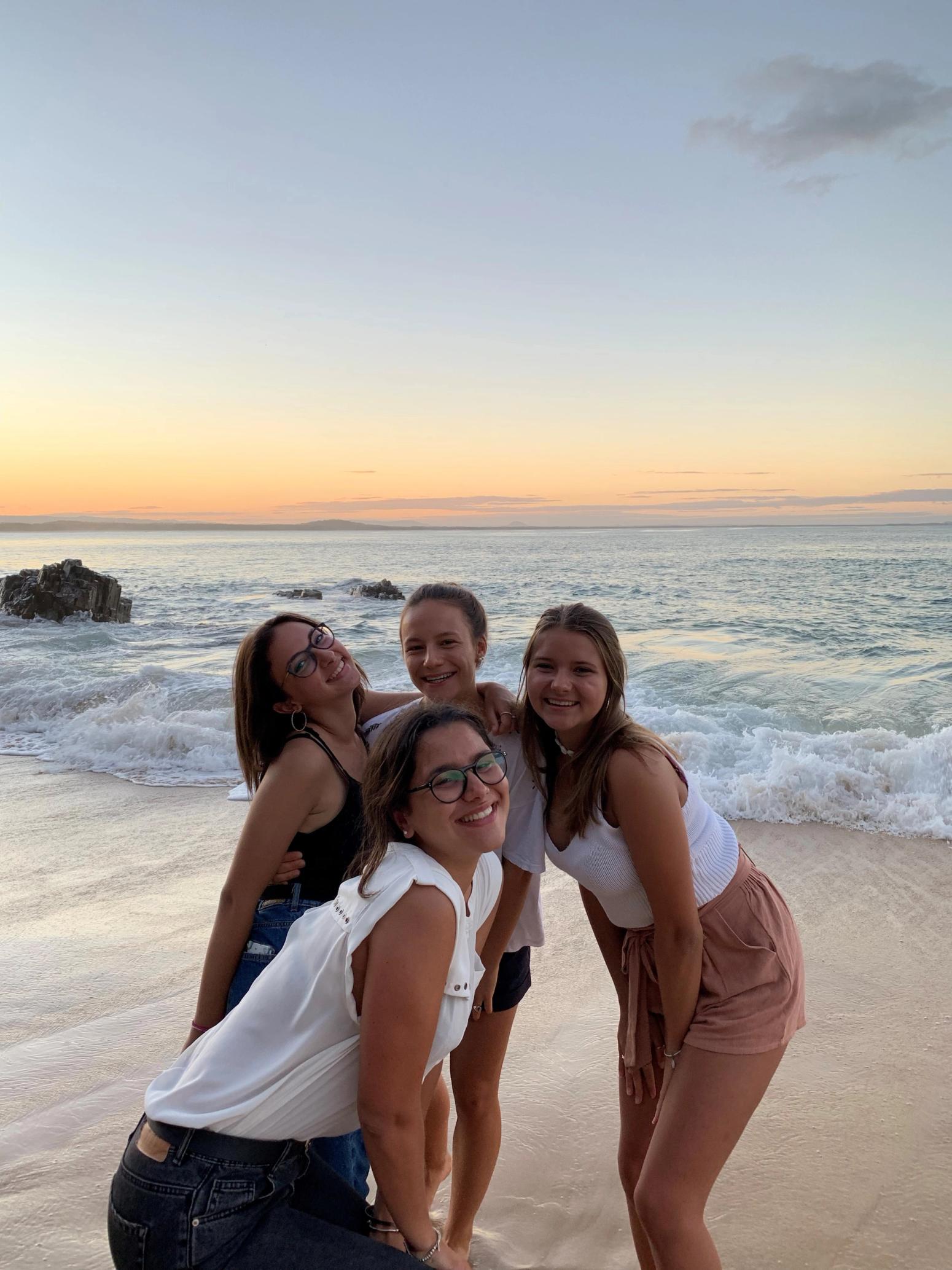 Gruppe von jungen Frauen die am Strand für eine Bild posieren