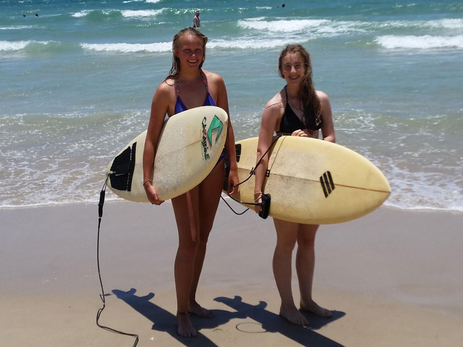 Zwei jungen Surferinnen posen für ein Bild