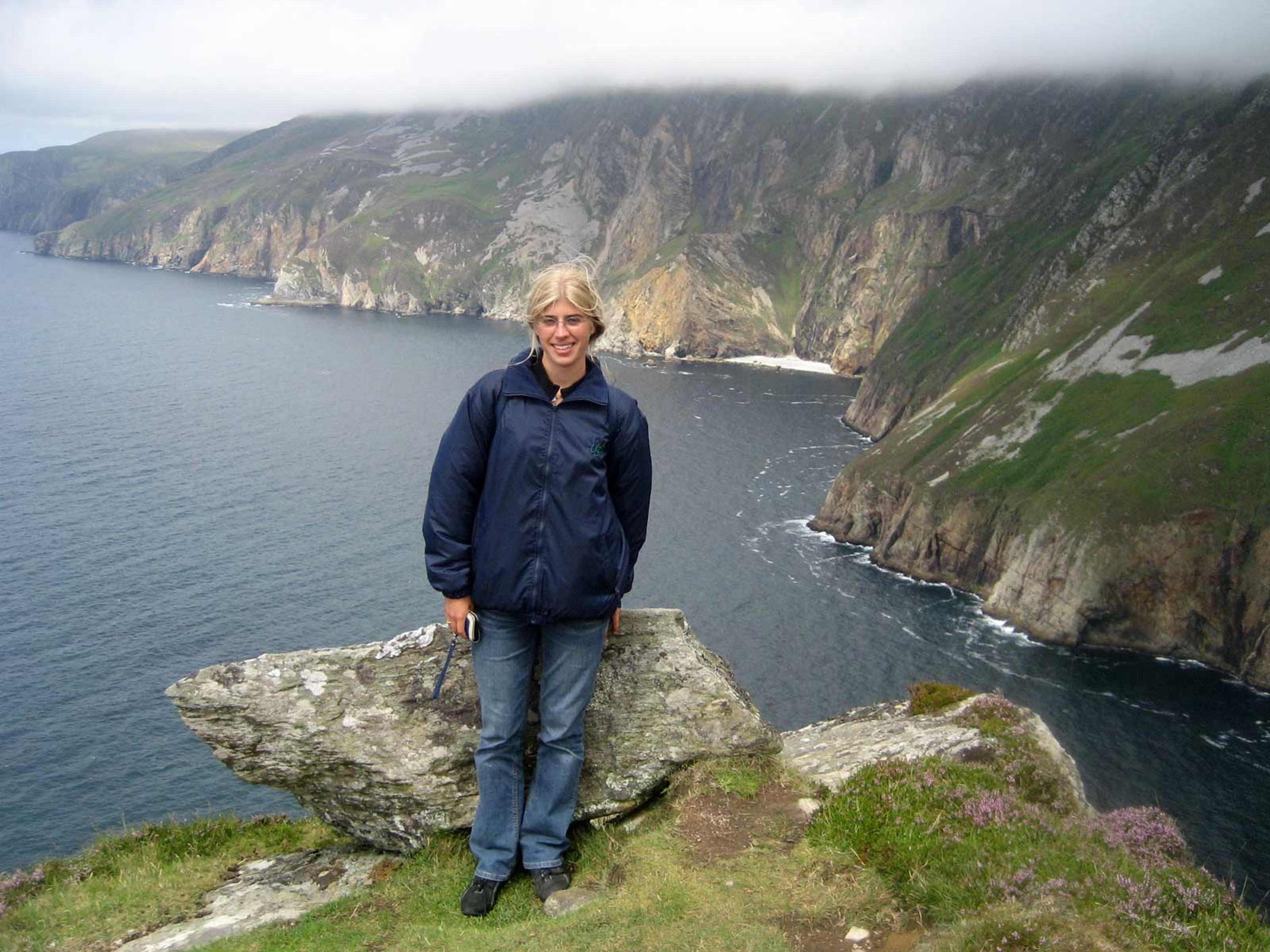 Blondes Mädchen vor einer Klippe in Irland