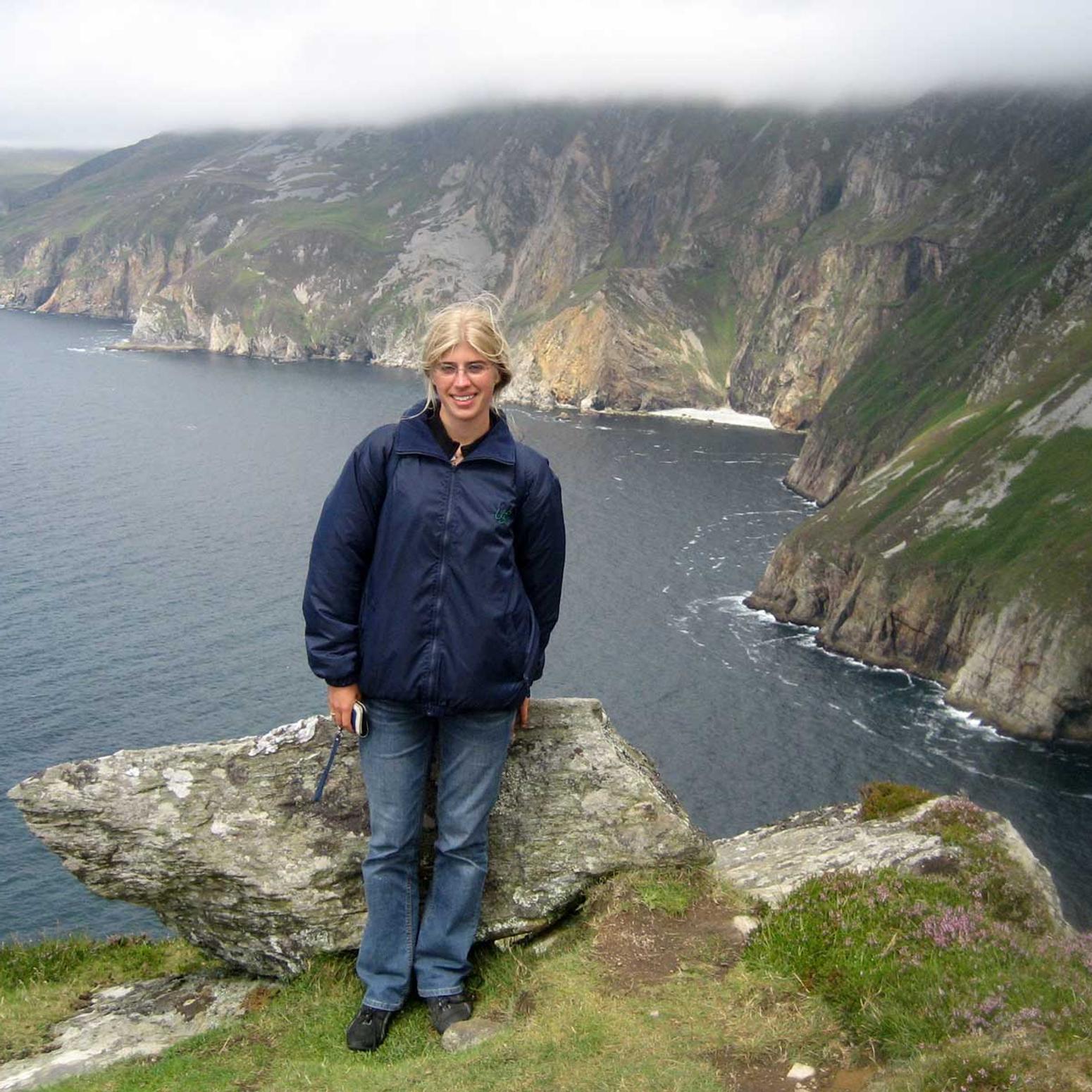 Blondes Mädchen vor einer Klippe in Irland