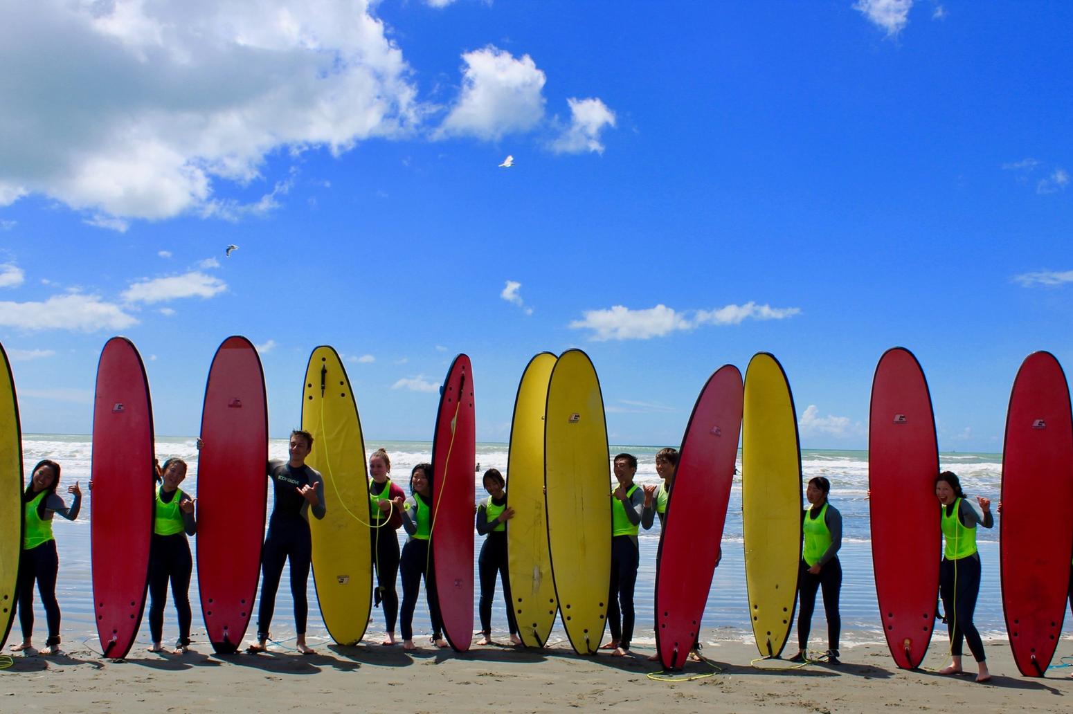 Ashburton College Christchurch Surfer:innen am Strand mit roten und gelben Surfbrettern