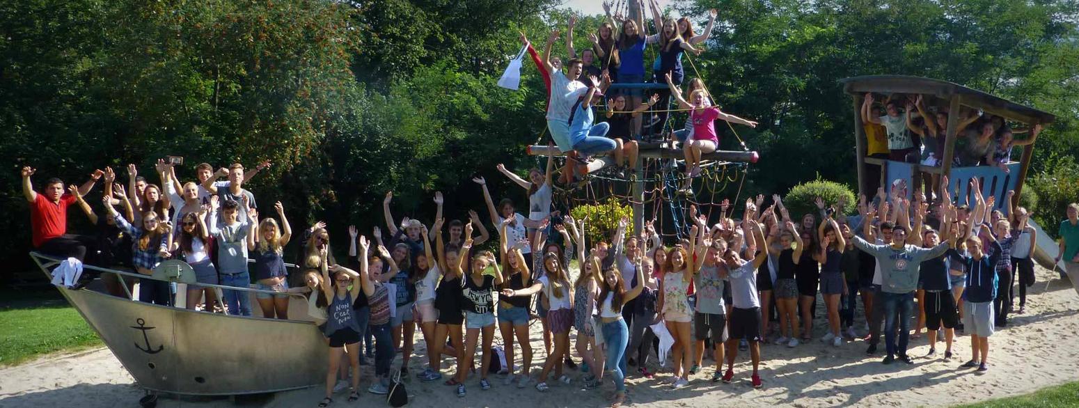 Bild von einer Gruppe Jungendlicher die auf einem Spielplatz für ein Foto posieren 