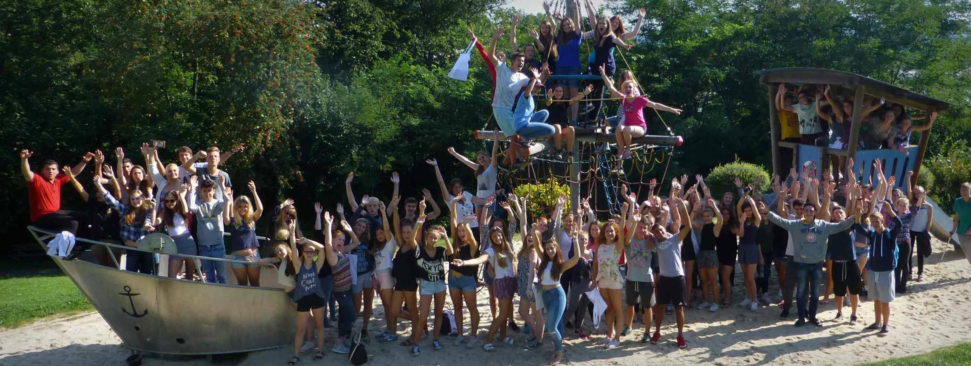 Bild von einer Gruppe Jungendlicher die auf einem Spielplatz für ein Foto posieren