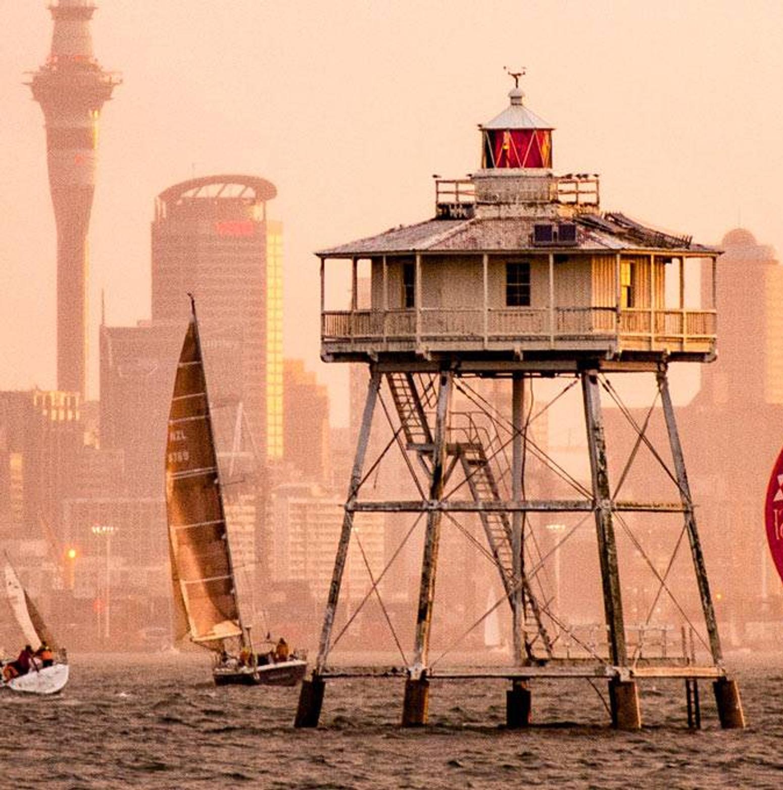 Bild einer Stadt und im Vordergrund sind fahren Segelboote