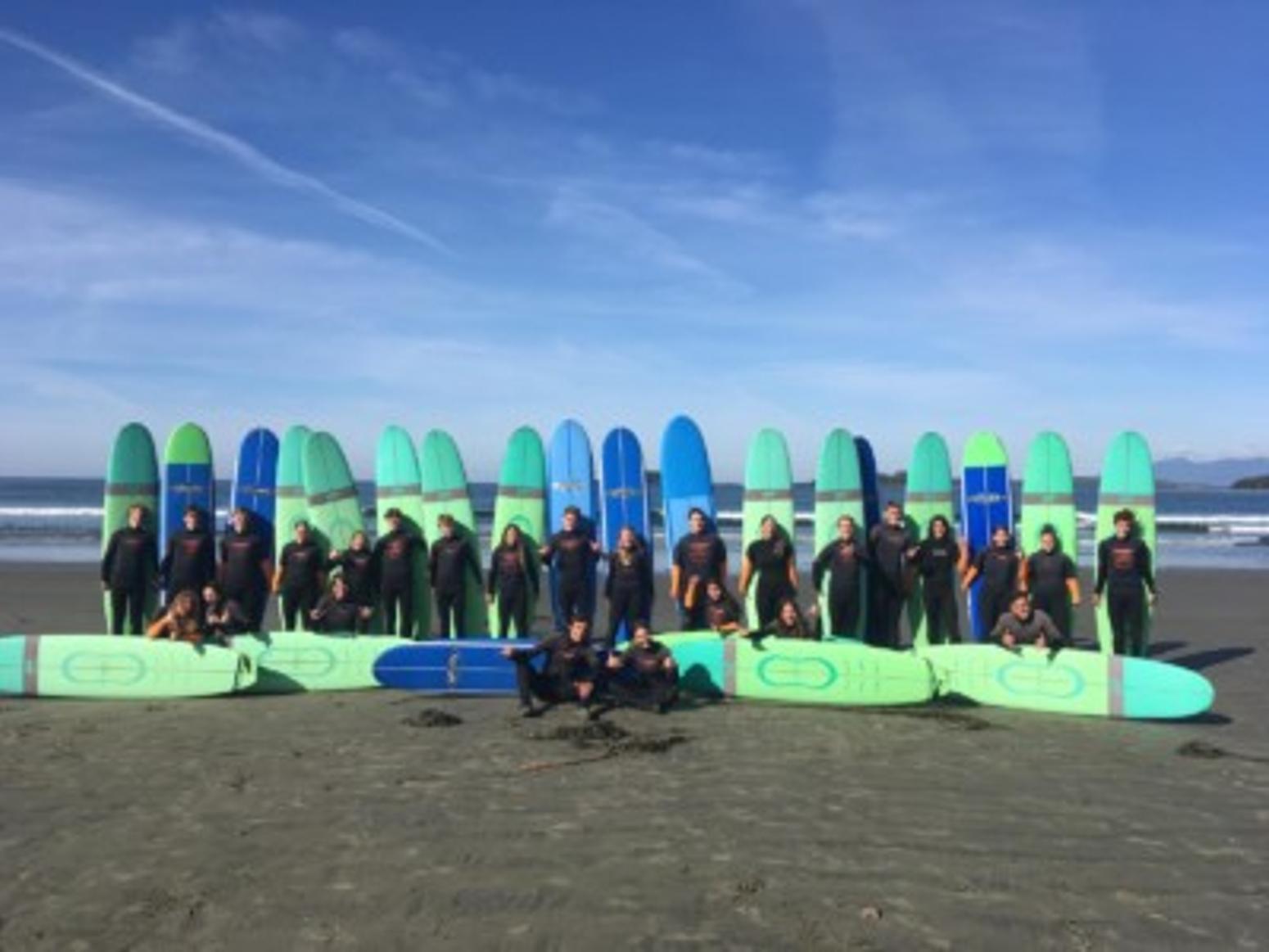Surfer und Surfbretter am Strand vor blauem Himmel Qualicum School District British Columbia Kanada