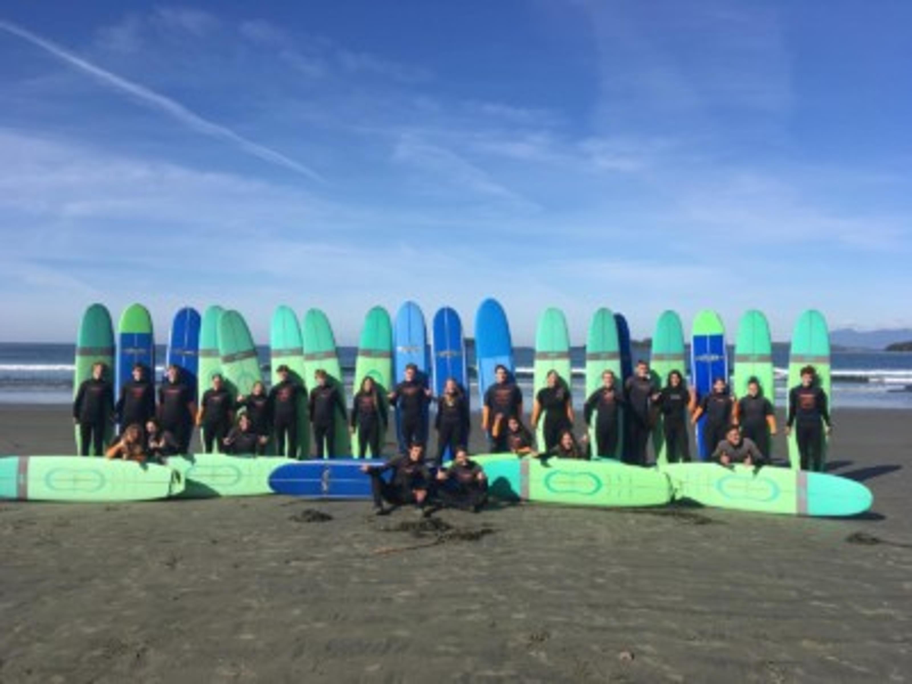 Surfer und Surfbretter am Strand vor blauem Himmel Qualicum School District British Columbia Kanada