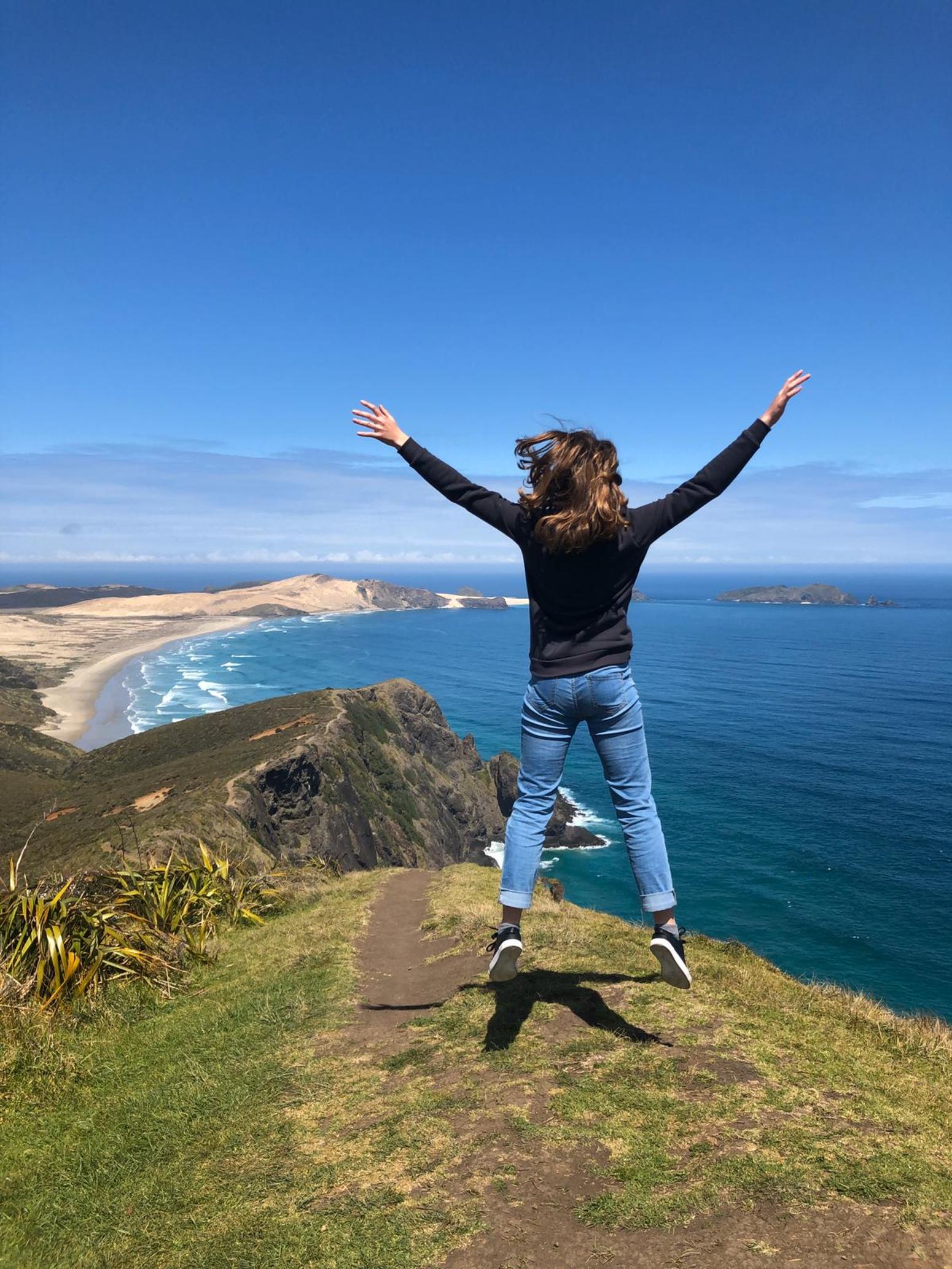 Frau springt auf einem Berg in die Luft