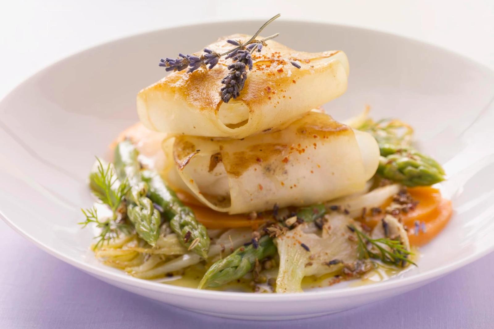 Lotte enrobée de pommes de terre sur un mélange de fenouil et d'asperges