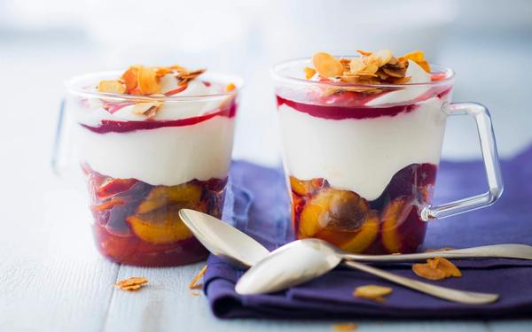 Coupe crémeuse aux quetsches en sirop, coulis de groseilles et amandes effilées caramélisées