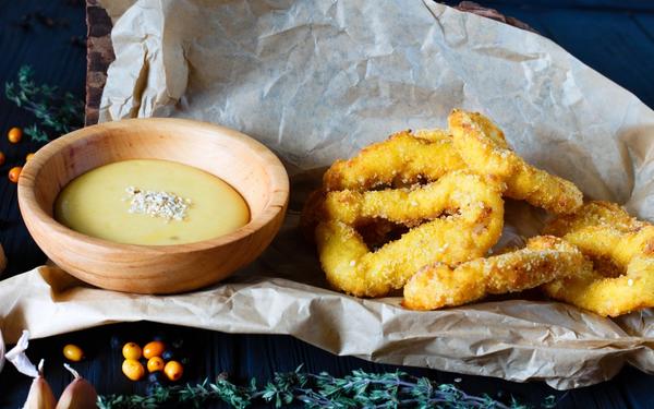 Anneaux d’oignon frit panés avec sauce crémeuse