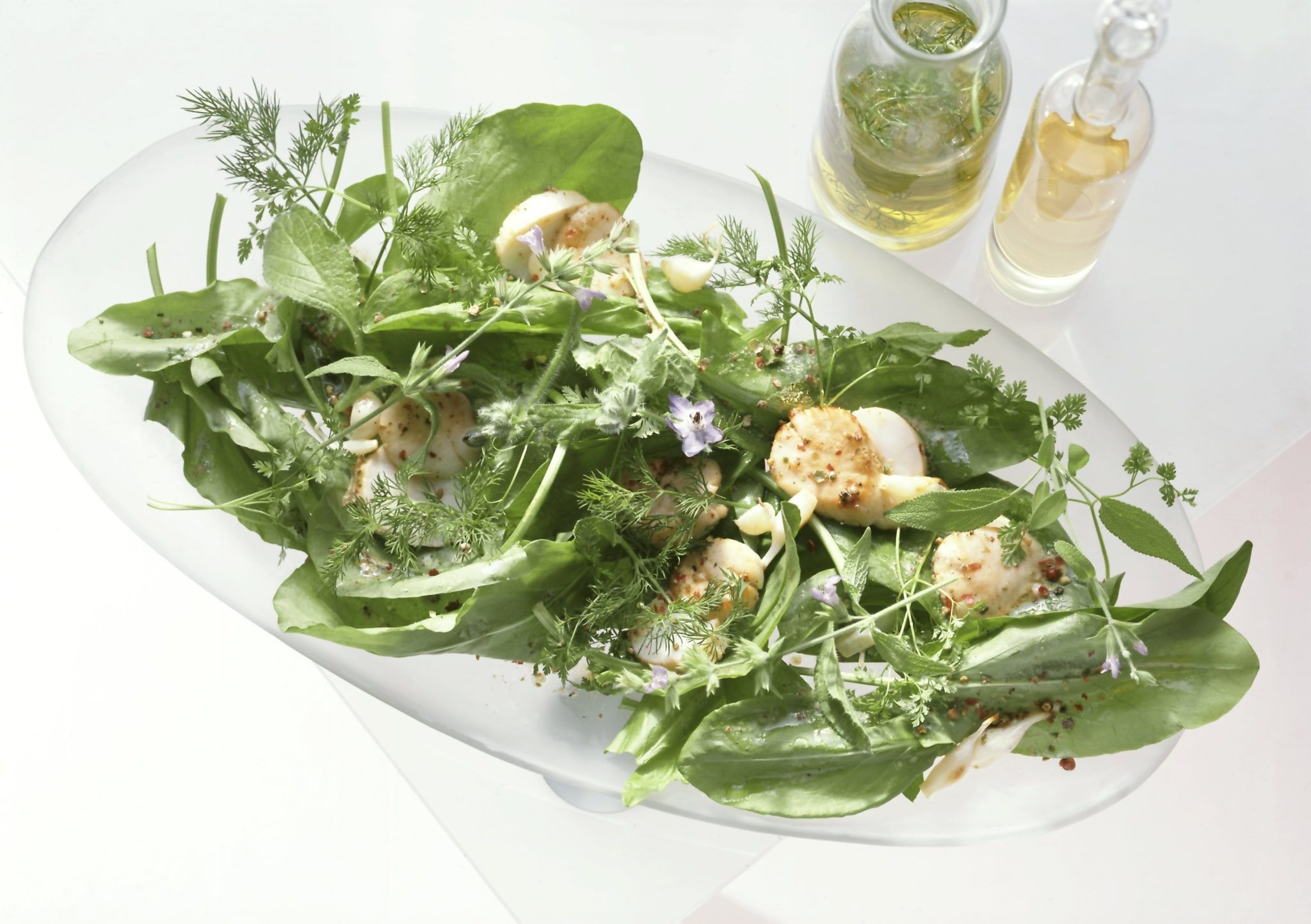 Salade d’oseille, herbes fraîches et fleurs, noix de Saint-Jacques poêlées