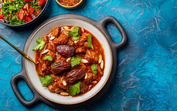 Tajine d’agneau marocain traditionnel aux épices, aux dattes et amandes