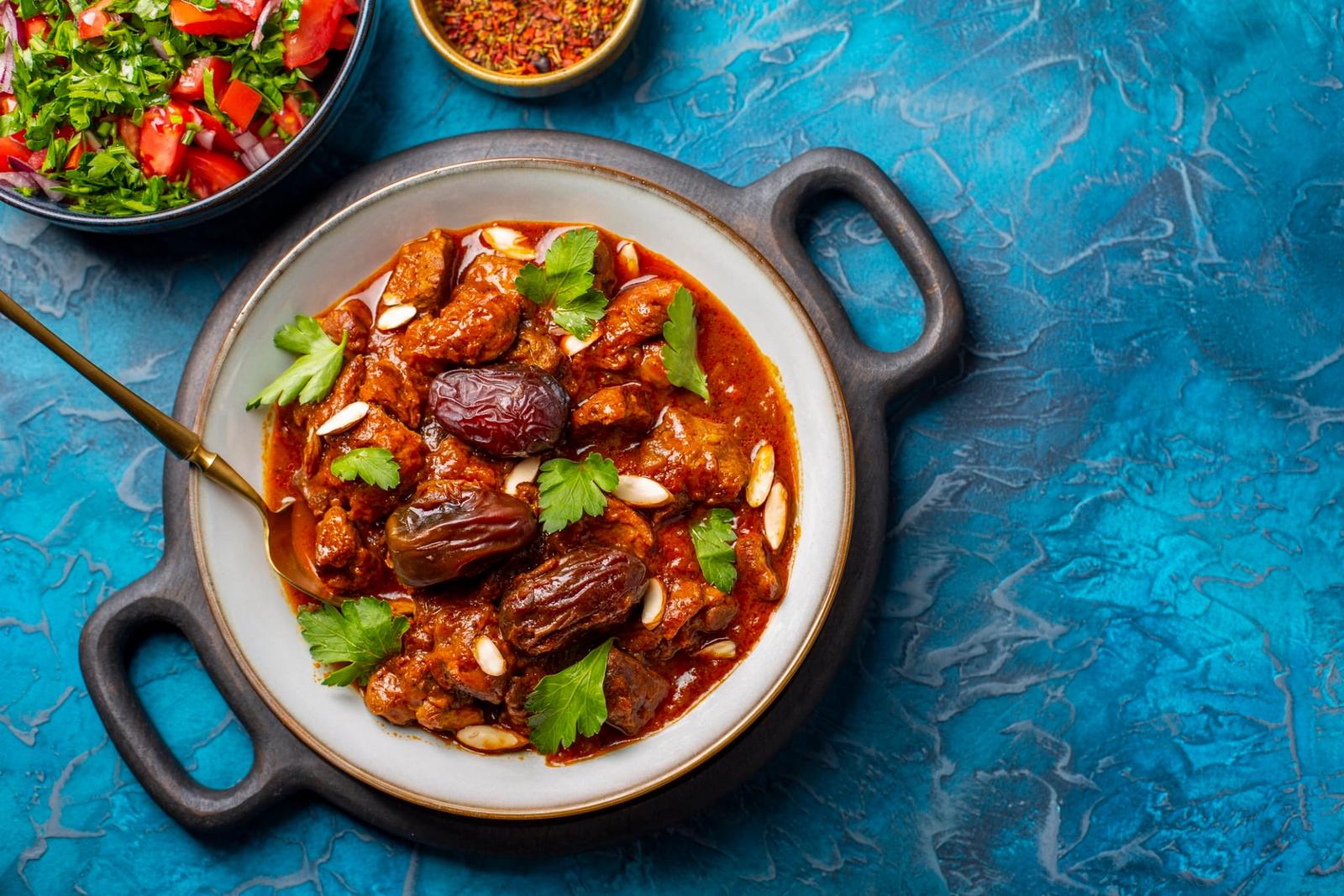 Tajine d’agneau marocain traditionnel aux épices, aux dattes et amandes