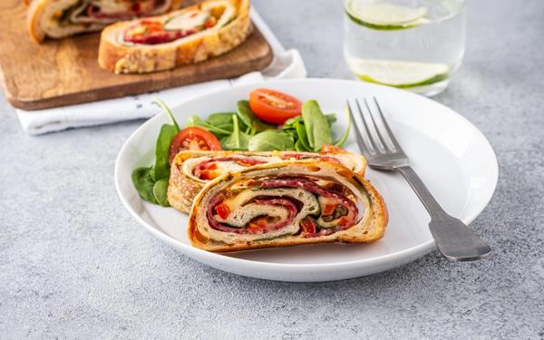 Pizza roll stromboli avec fromage, salami, épinards et poivron rouge