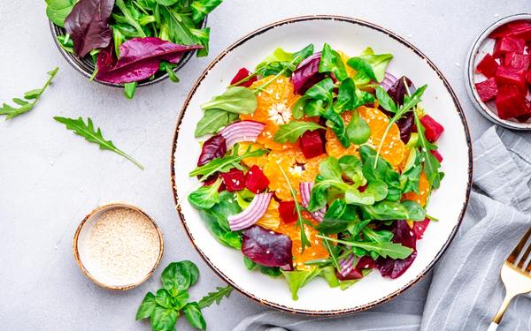 Salade vegan de betteraves rôties, mandarines, oignon rouge, jeunes pousses, roquette et sésame