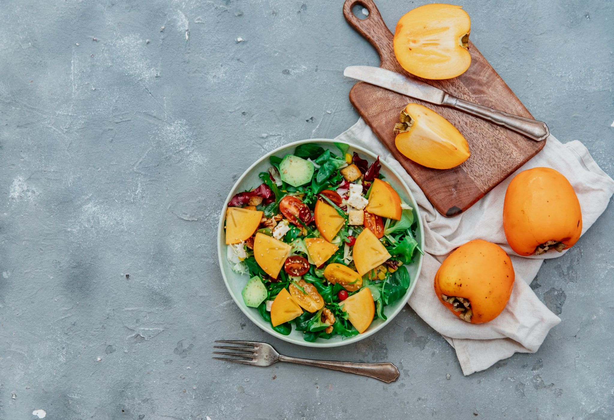 Salade de roquette, kakis, noix et légumes croquants
