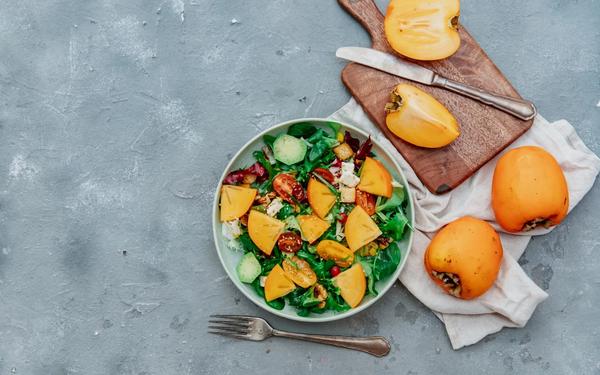 Salade de roquette, kakis, noix et légumes croquants
