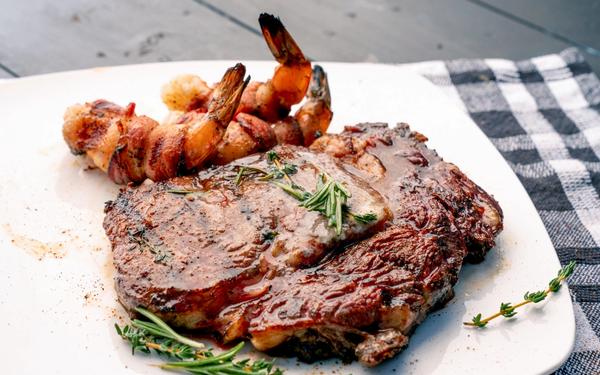Steak de ribeye au thym et au romarin avec crevettes au bacon