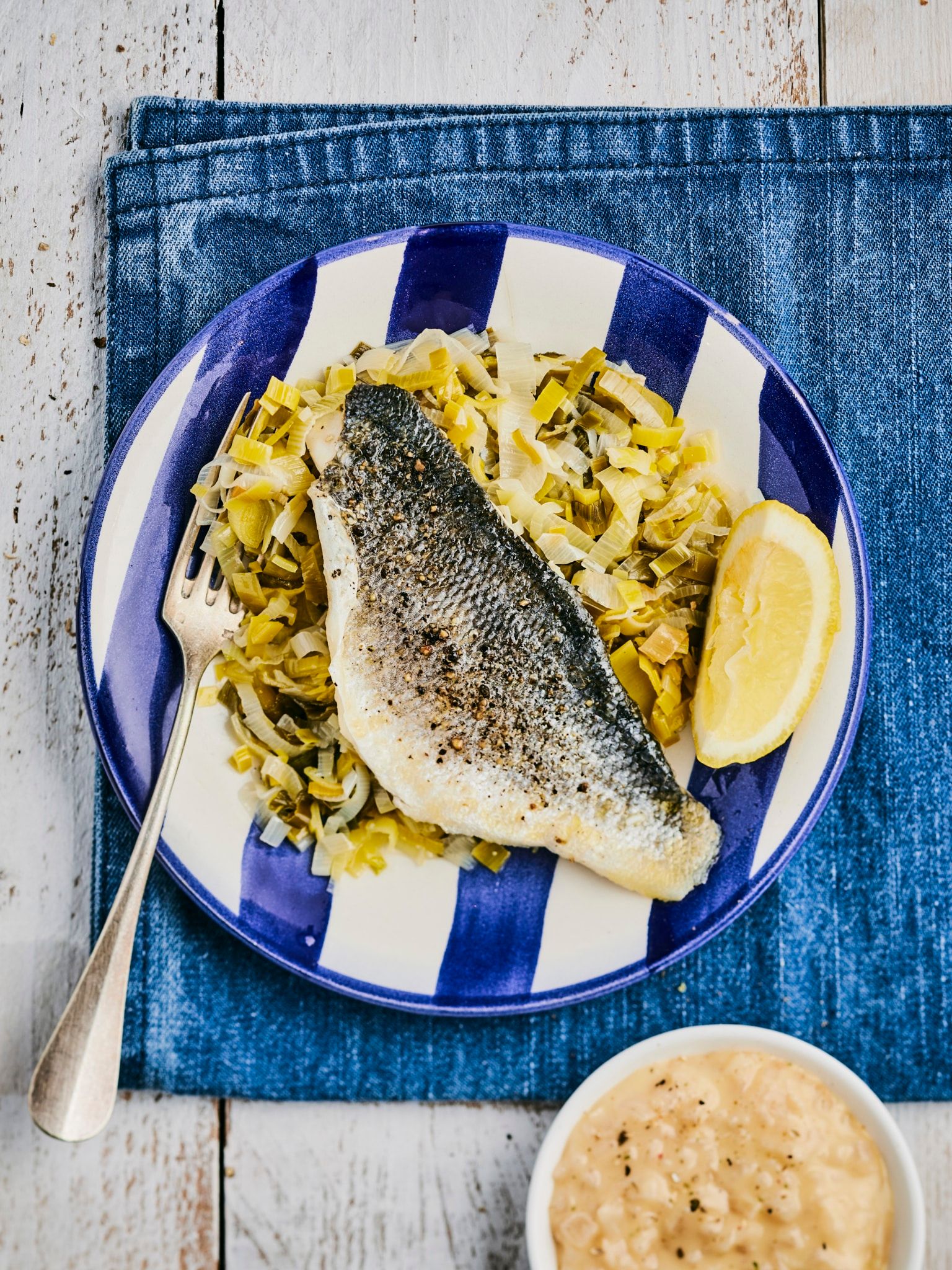 Filet de bar au beurre citronné sur un lit de poireaux