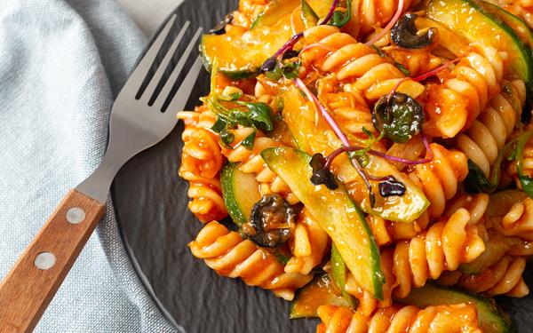 Salade de pâtes fusilli, courgettes, olives, à la sauce tomate