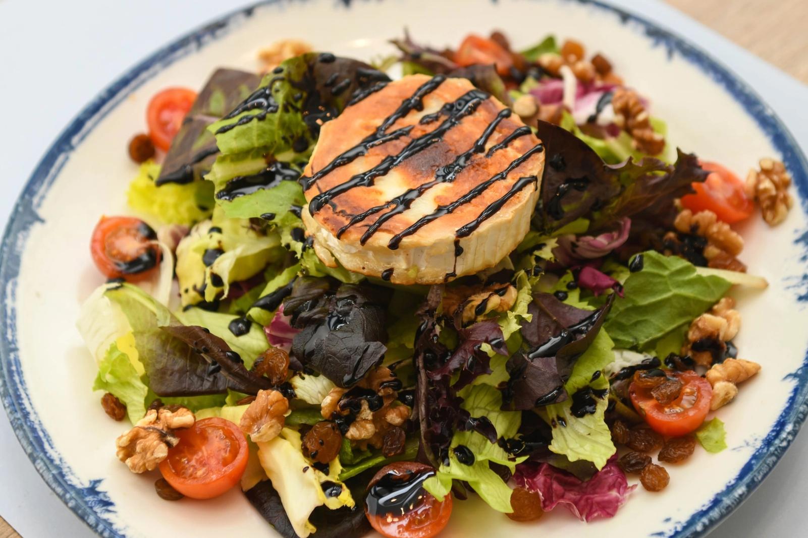 Salade de fromage de chèvre grillé, noix, tomates cerises et laitue