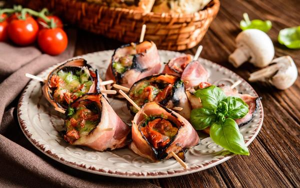 Champignons farcis au fromage, tomates séchées enveloppés dans du bacon