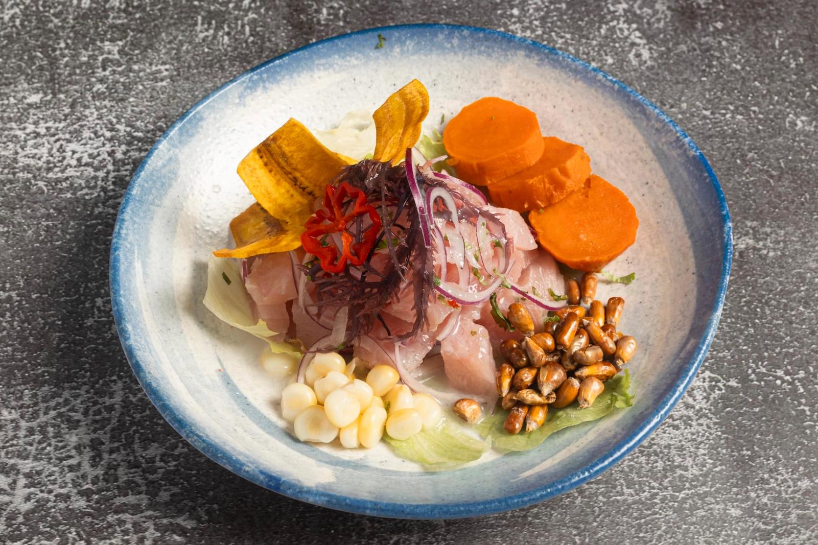 Ceviche de poisson, plantain frit, patate douce, cancha et oignon rouge