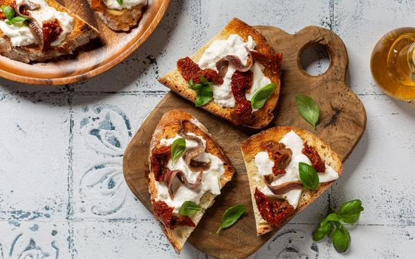 Crostini à la tomate séchée, anchois, basilic et burrata