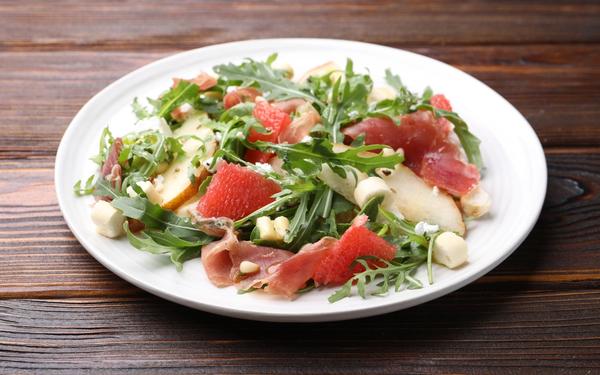 Salade de roquette avec prosciutto, fromage, poire, pamplemousse et noix