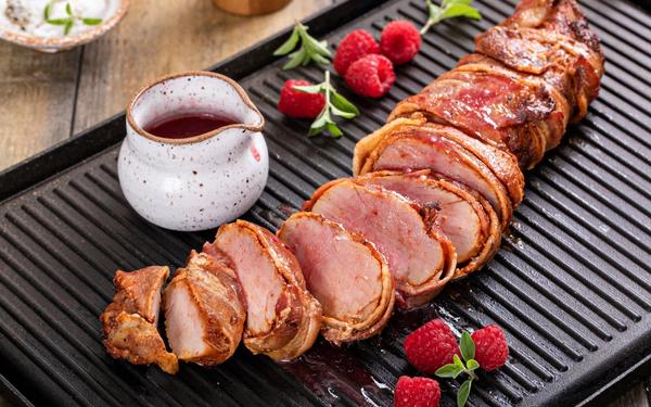 Filet de porc enveloppé dans du bacon avec vinaigrette à la framboise