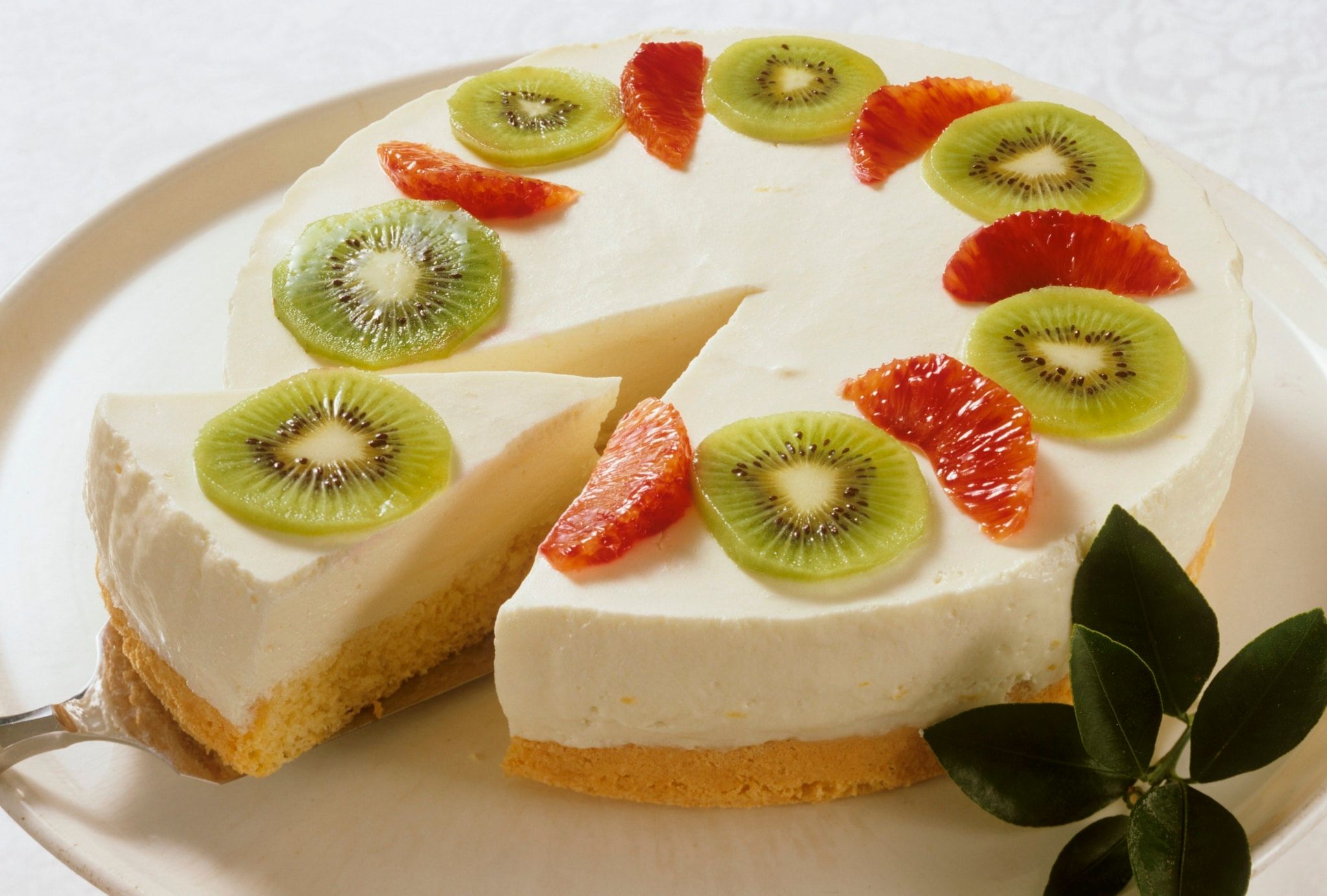 Gâteau au fromage crémeux avec des kiwis et des oranges sanguines