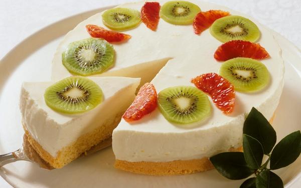 Gâteau au fromage crémeux avec des kiwis et des oranges sanguines