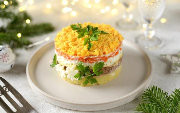 Salade russe au caviar rouge, poisson, pommes de terre, fromage, carottes et œufs