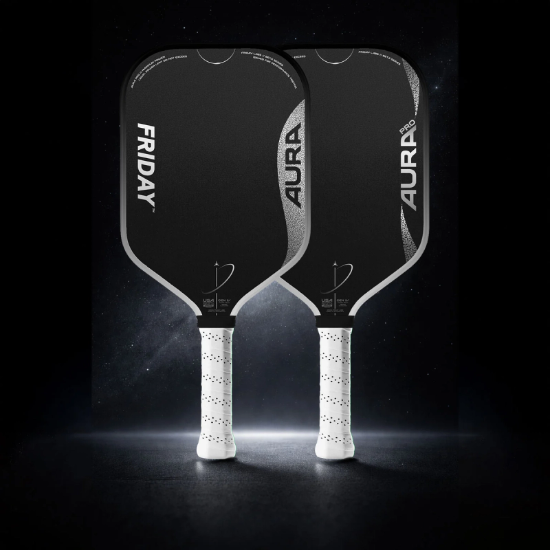 Two Friday Aura paddles with black faces and white grips against a dark starry background.