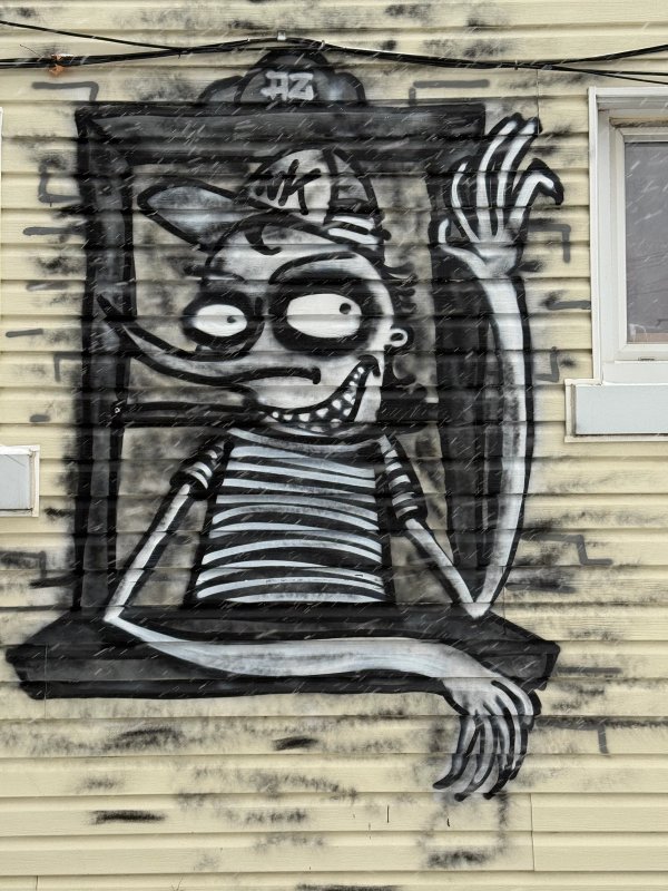 Black and white street art mural of a stylized, grinning figure by artist Azdead. Located in Hintonburg, Ottawa. Documenting art from the Urban Art Collective Disrupt 2023.