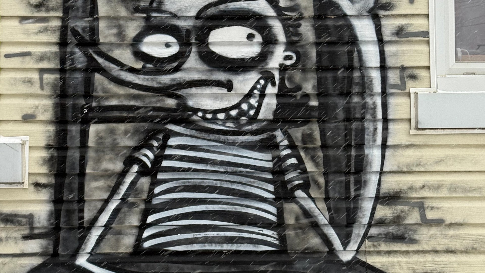 Black and white street art mural of a stylized, grinning figure by artist Azdead. Located in Hintonburg, Ottawa. Documenting art from the Urban Art Collective Disrupt 2023.