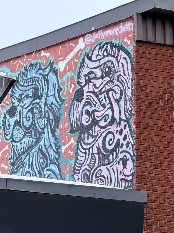 Public mural in the Rideau Gardens neighborhood of Ottawa featuring expressive canine illustrations and bone motifs.