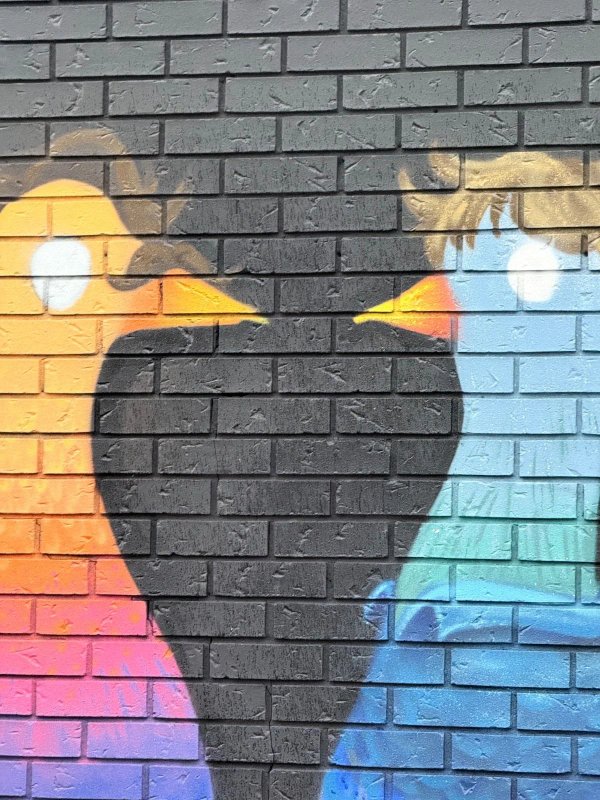 Colorful, large-scale mural featuring graphic, stylized "Pigeon People" figures and symbols