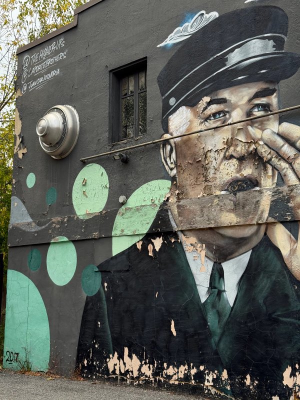 Contemporary realism mural blending a uniformed man and a huge face with calligraphic graffiti script. Urban Art Index, Lowertown. OTTAWALLS.