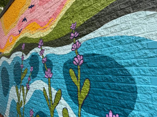Ottawa Abstract Floral Mural on brick. Stylized lavender flowers, blue water waves, and pink/yellow sunset sky. Contemporary Folk Art.