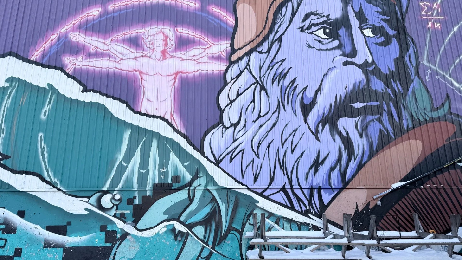 Large-scale outdoor mural by Ottawa artists Dems and Doll in Centretown, depicting a bearded figure reminiscent of Leonardo da Vinci alongside the Vitruvian Man and dynamic water imagery, painted on a building exterior in winter