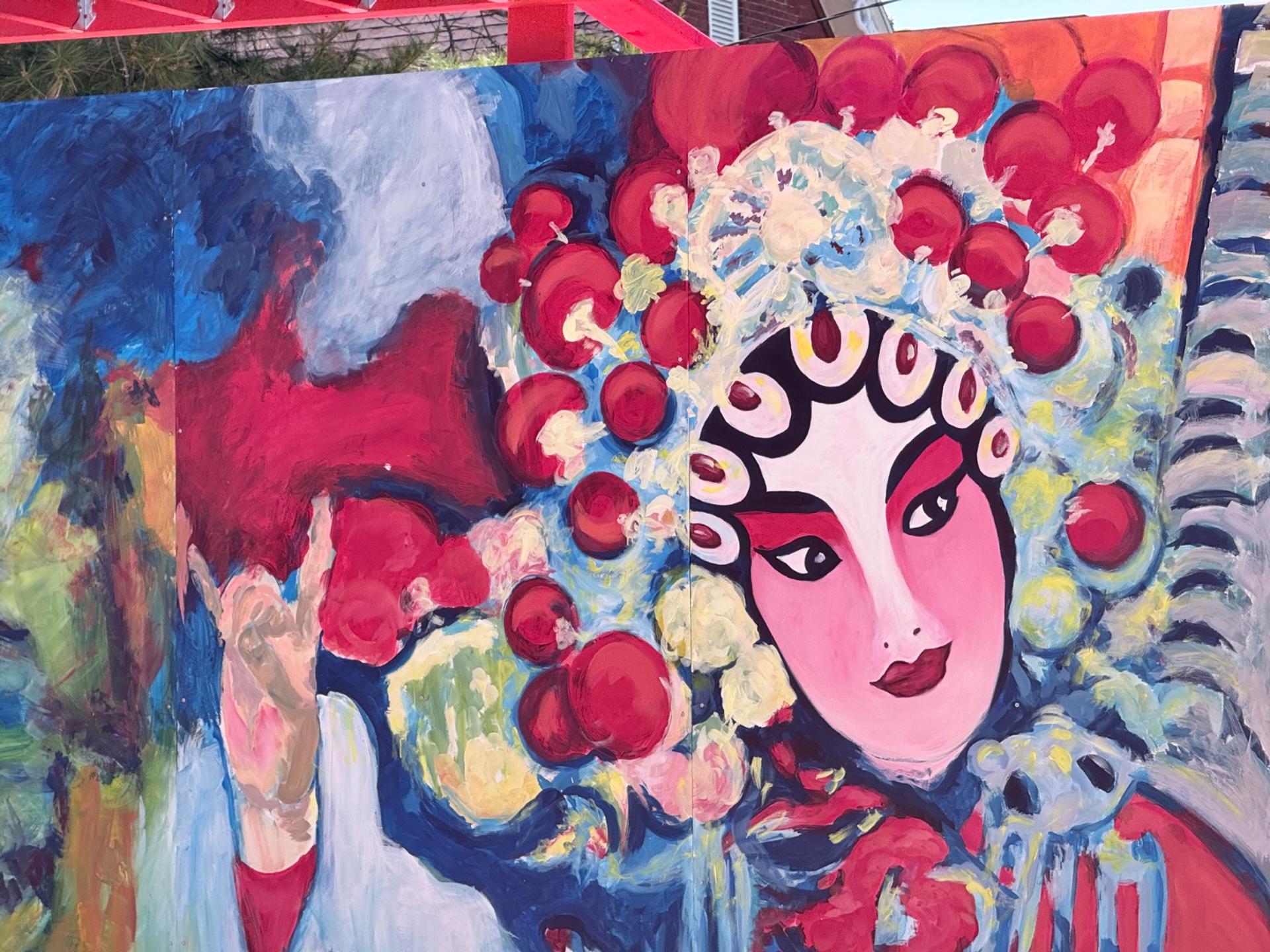 Fresque « Bienvenue à Chinatown » réalisée par Yi Chang au 700, rue Somerset Ouest, représentant un masque d’opéra de Pékin coiffé d’une coiffe rouge, avec un texte en cursive dorée sur fond bleu, dans le quartier chinois d’Ottawa