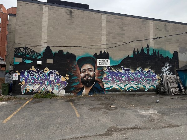 Wide-angle view of the large-scale Bender tribute wall, showcasing iconic Ottawa street art in its urban environment. Painted by the Higher Ups, this project highlights the talent of the local Ottawa muralist community and is a landmark among Ottawa murals.