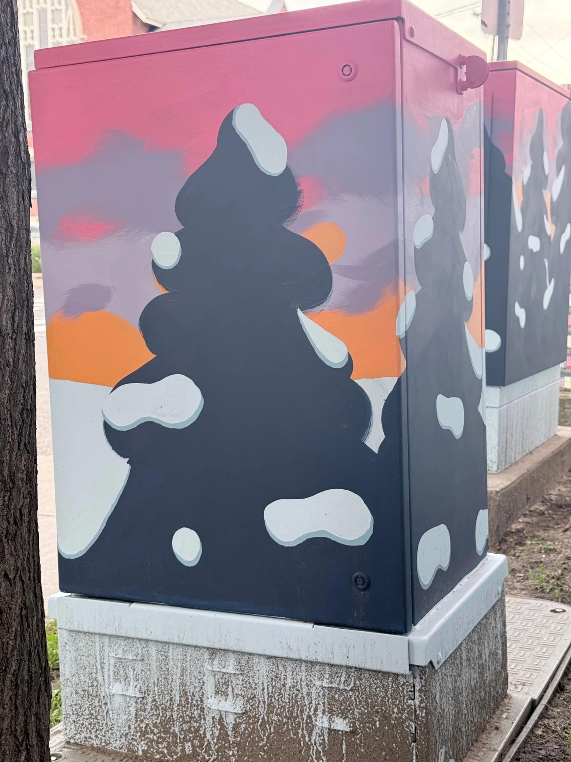 A utility box mural shows a stylized dark tree silhouette with white snow patches against a pink-orange sunset sky in The Glebe, Ottawa.