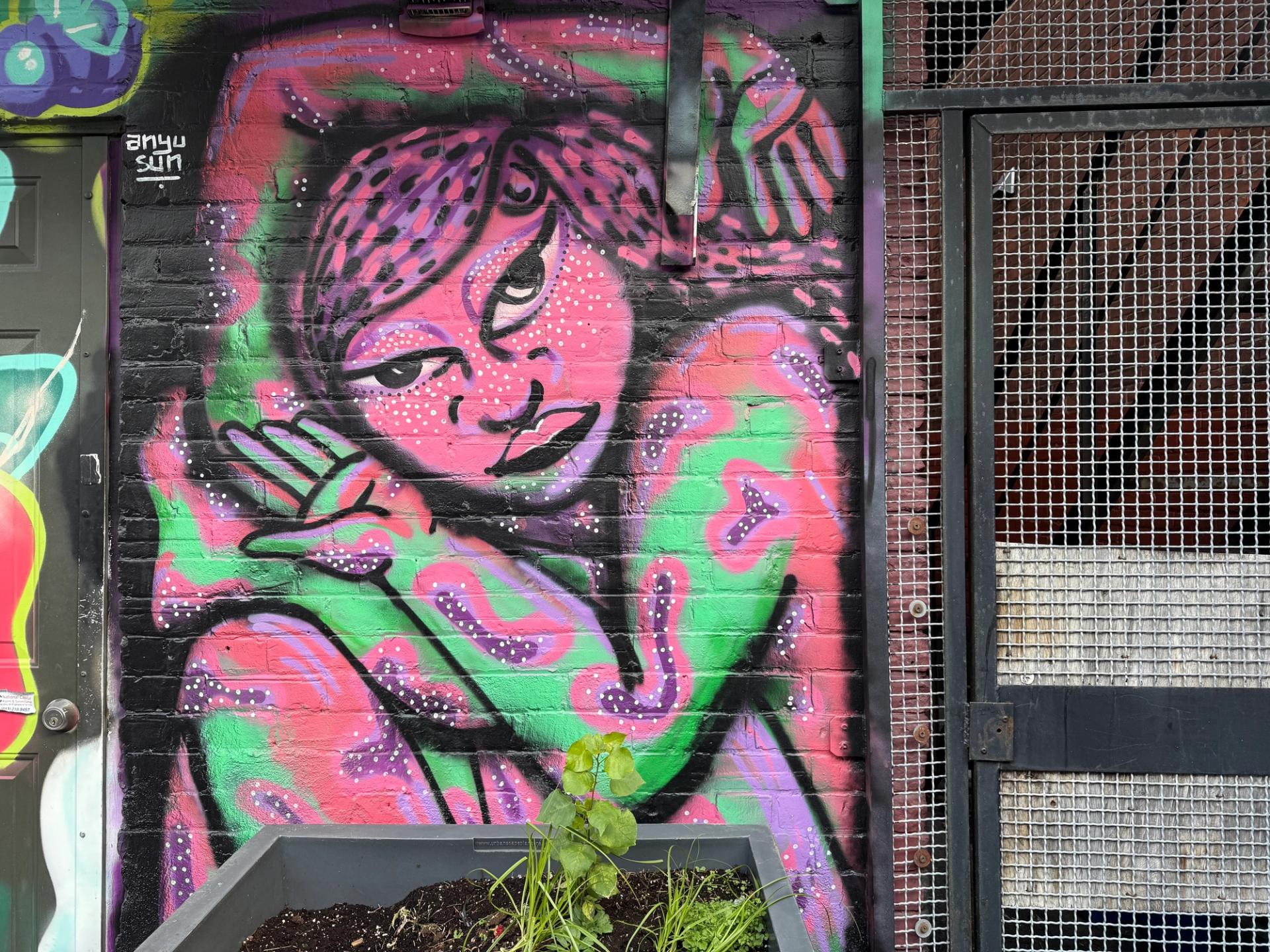 Detail of The Contortionist 2.0 mural by Anyu Sun at Arlington Five in Ottawa, showing the expressive colours and form of a pink contortionist figure pushing against societal expectations, 2024