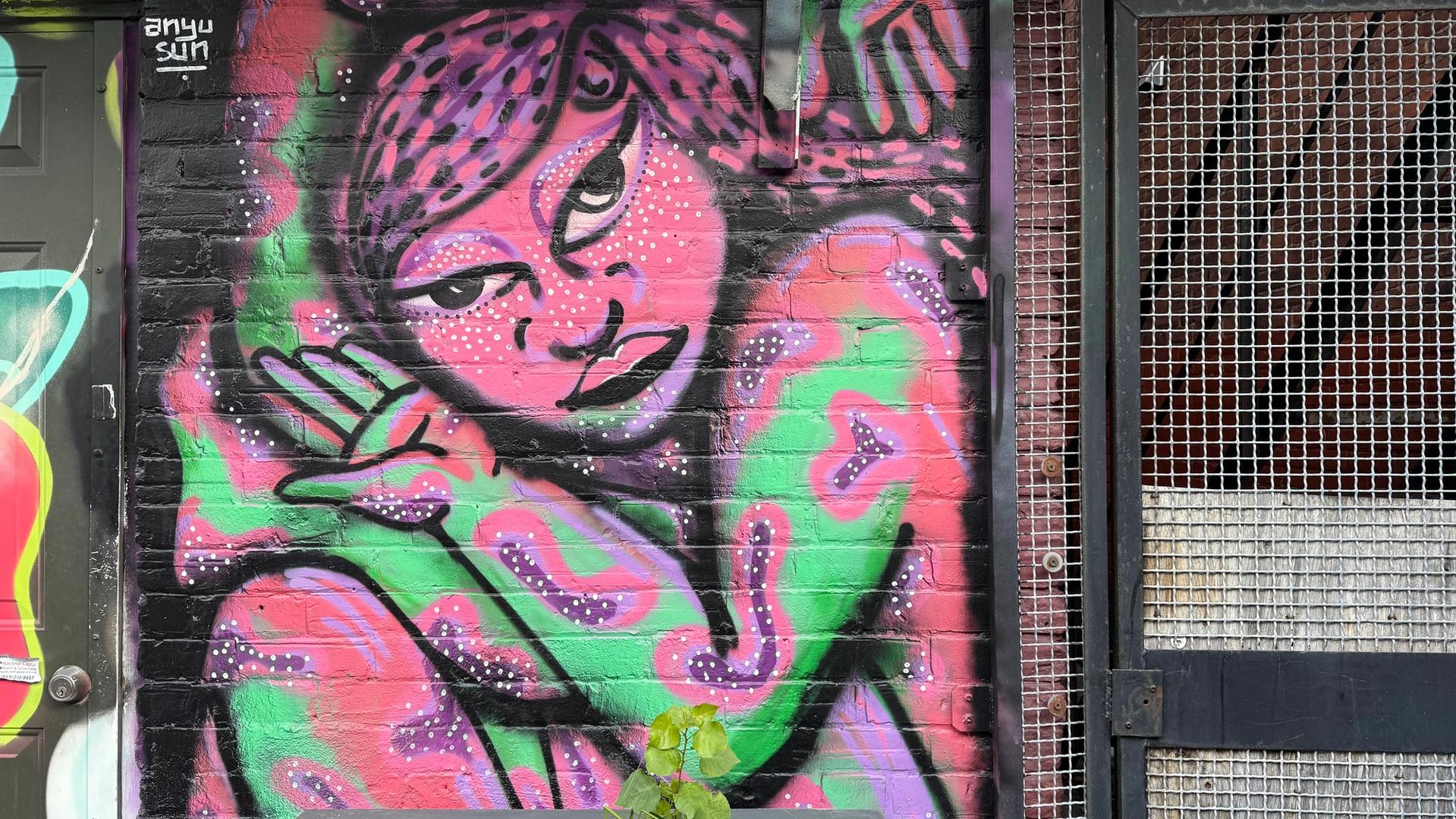 The Contortionist 2.0 mural by Anyu Sun at Arlington Five in Ottawa, showing a pink female figure bent into an impossible contortionist shape against a bright colourful background, 2024.